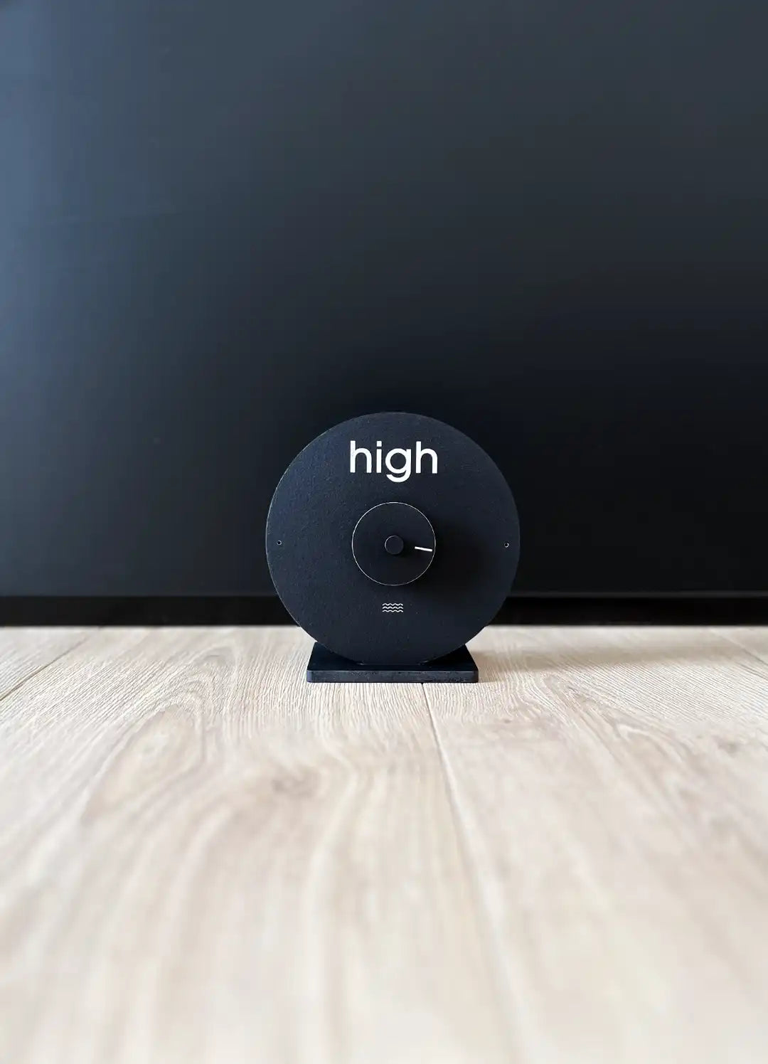 horloge des marées noires posée sur un sol en parquet en bois