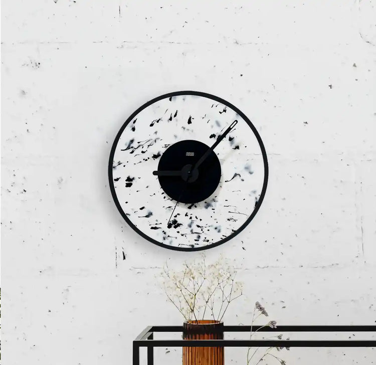 horloge blanche et noire tachetée accrochée au mur
