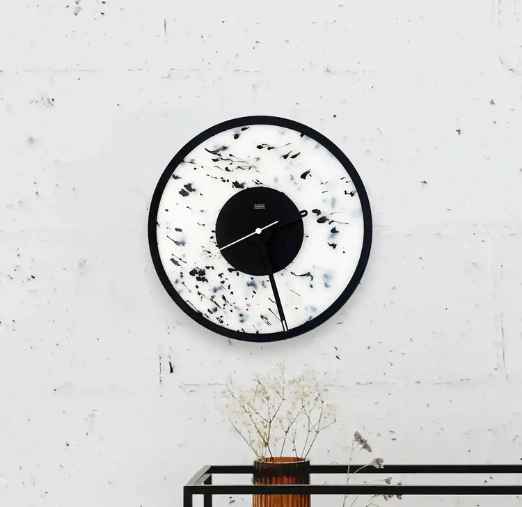 horloge blanche et noire tachetée accrochée au mur
