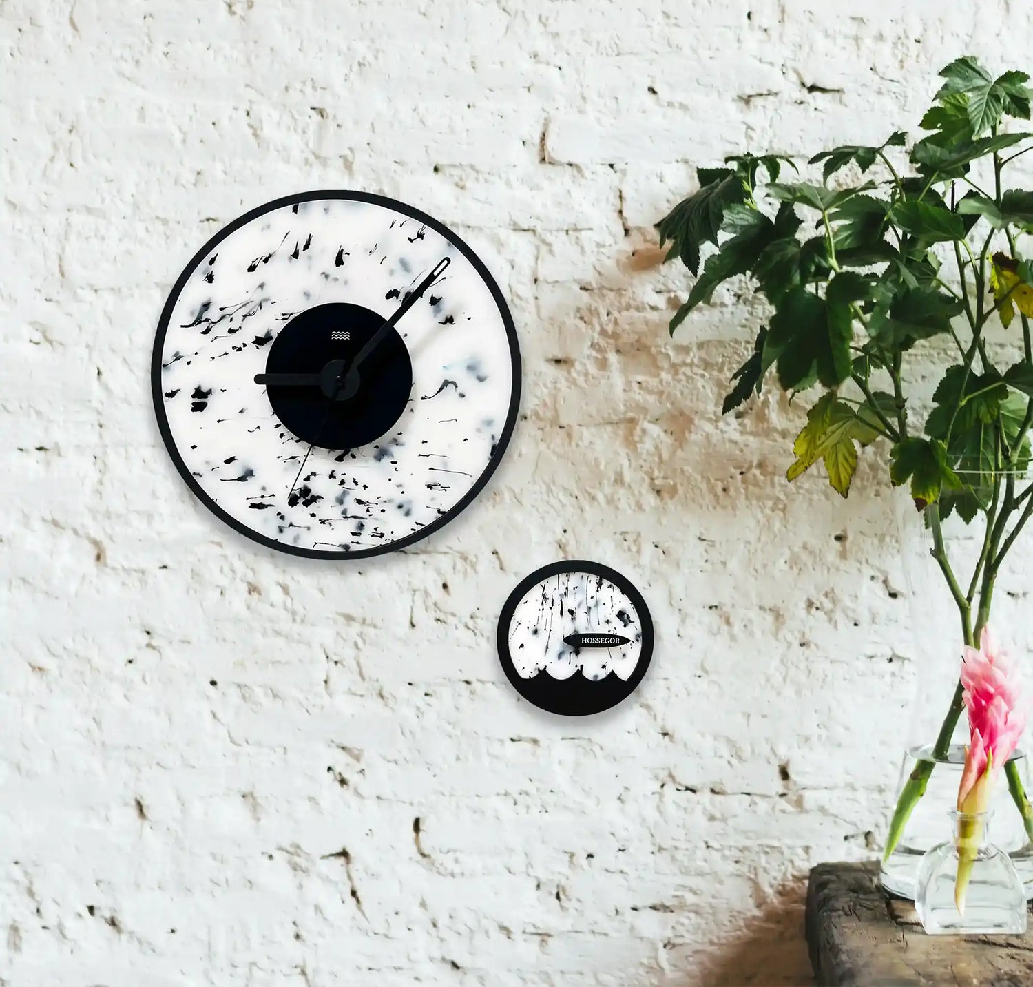 une horloge blanche et noire, et une horloge des marées  blanche accrochées à un mur 