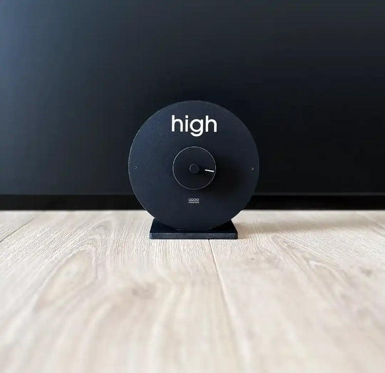 horloge des marées noires posée sur un sol en parquet en bois