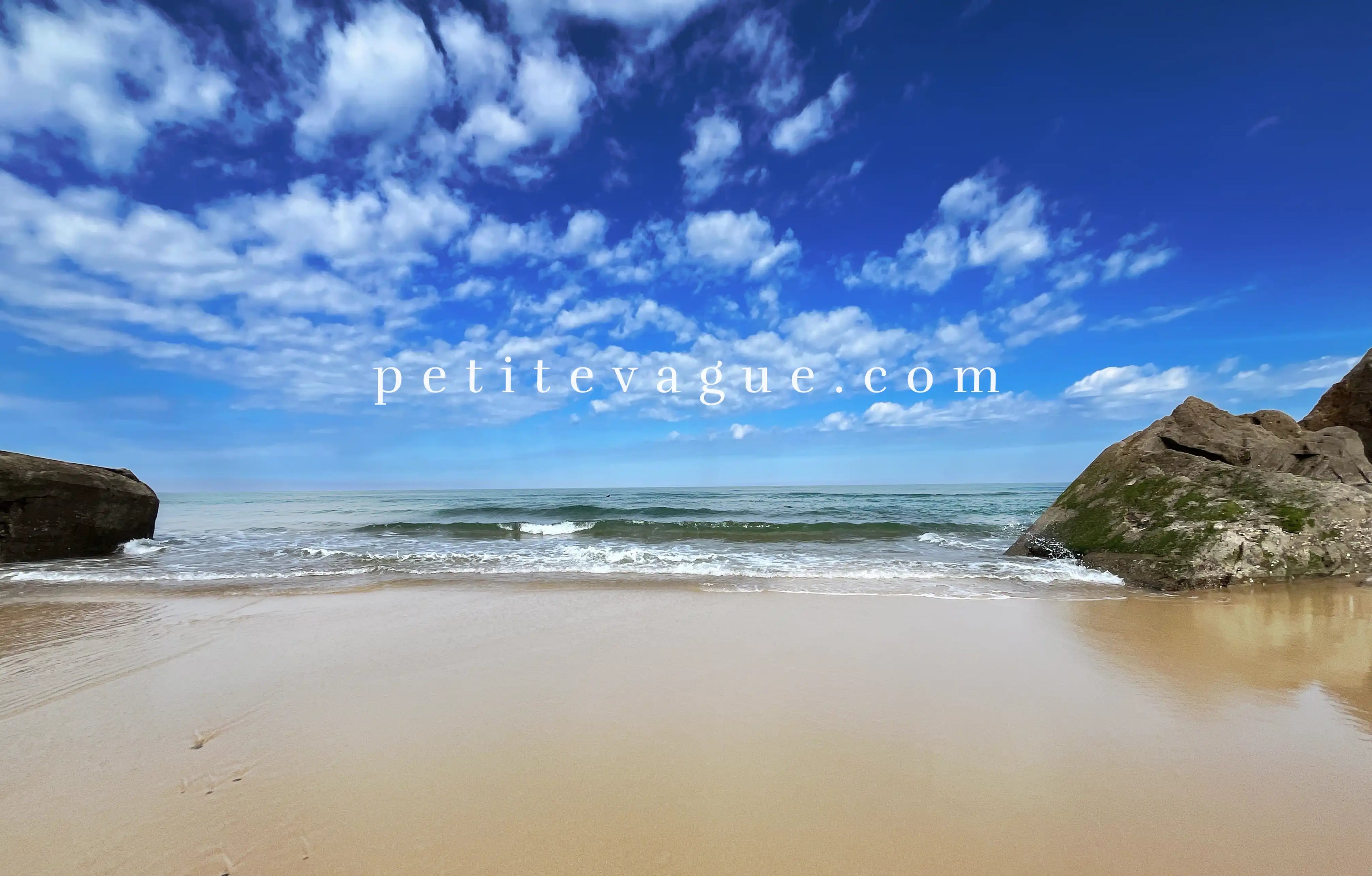Fond d'écran à télécharger représentant une vague qui se brise sur le sable. Le texte 'petitevague.com' est écrit au centre de l'image."