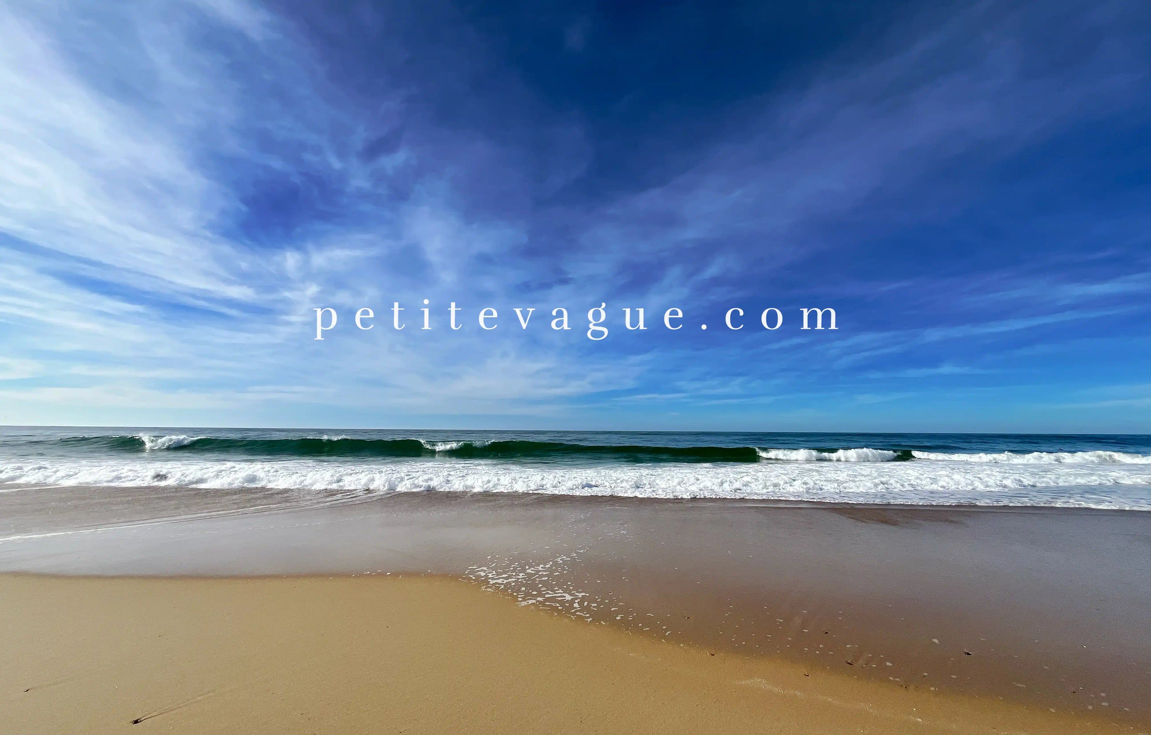 Fond d'écran à télécharger représentant une vague qui se brise sur le sable. Le texte 'petitevague.com' est écrit au centre de l'image."